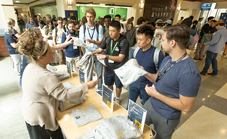 Incoming graduate students collect College of Engineering welcome materials during a reception.