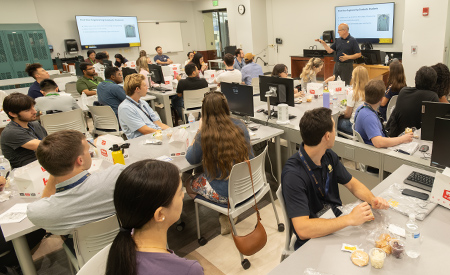 Incoming graduate students attend a welcome presentation during lunch.