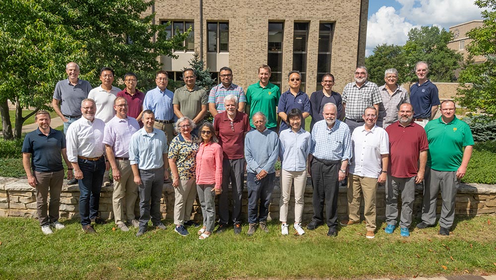 Electrical Engineering faculty members pose for a group photo outdoors on the Notre Dame campus.