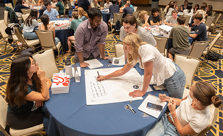 Students work together at a table during the Notre Dame Innovation Challenge kickoff.