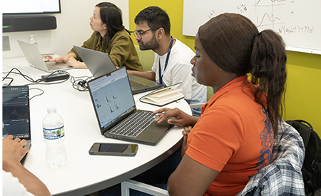 Students work on laptops together during a bioengineering research session.