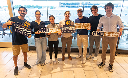 Students pose with Notre Dame Innovation Challenge signs during the kickoff event.