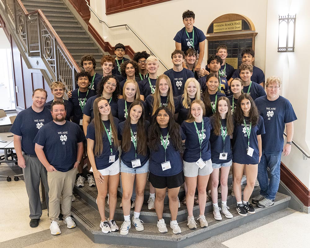 Electrical engineering pre-college summer camp students and instructors pose for a group photo inside Stinson-Remick Hall.