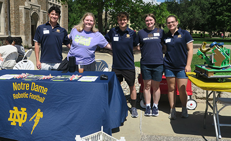 Notre Dame Robotic Football student organization members pose at their information table.