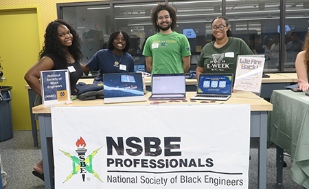 National Society of Black Engineers members pose at their Welcome Weekend table.